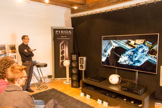 Thomas Flammer von voice70 zeigt mit einem Heimkino-Setup aus Devialet-Phantom-Lautsprechern und einem 75-Zoll-Panasonic-Fernseher, was für ein faszinierendes Erlebnis aus grossem Bild und hochwertigem Audio entsteht.