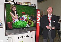 Heinz Häner, Mediensprecher bei JVC, demonstriert den imposanten HD-70ZR7 Hybrid-Fernseher.