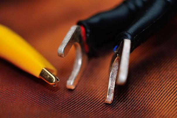Kabelschuhe an Lautsprecherkabel konfektioniert. Die Klemme links dient dem Anschluss des Pig-Tail-Leiters an die Gerätemasse (Potentialausgleich).