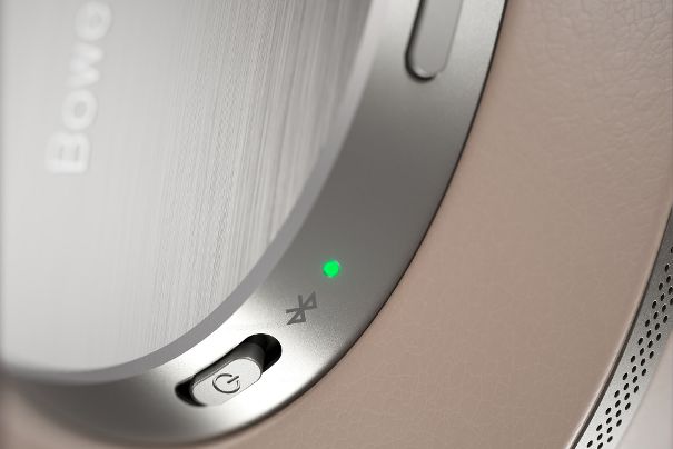 In der linken Hörmuschel ist die Taste für das Aktivieren von Noise Cancelling integriert (oberhalb des Schiebeschalters für Ein-/Ausschalten).