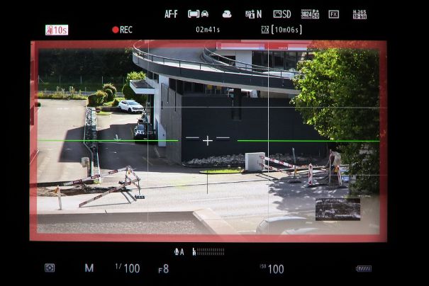 Kontrollen im Sucher der Nikon Z6 III: Virtueller Horizont in Grün, wenn im Lot, Gittermuster, Waveformmonitor rechts unten und Fadenkreuz. Die Motivwahrnehmung für Fahrzeuge ist aktiv und die Aufnahme läuft, bestätigt durch roten Balken und REC-Symbol.