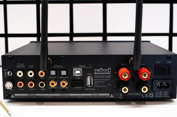 Von links: Phonoeingang für MM oder MC; Hochpegel-Eingang AUX; digitaler Link-Ausgang (SPDIF 24/96); analoger Sub-Ausgang, 4 SPDIF-Eingänge (2x TosLink, 2x Coax); USB-Eingang; Port für das aufschraubbare HDMI-Modul; LS-Anschlüsse; Nu-connect-WiFi-Antenne.